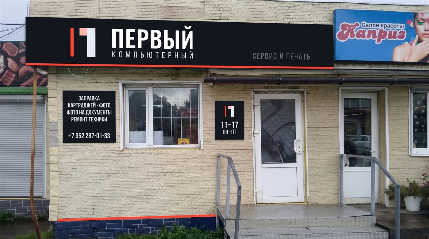 Вход в «Первый Компьютерный» в Рощино: чёрная вывеска с красной полосой